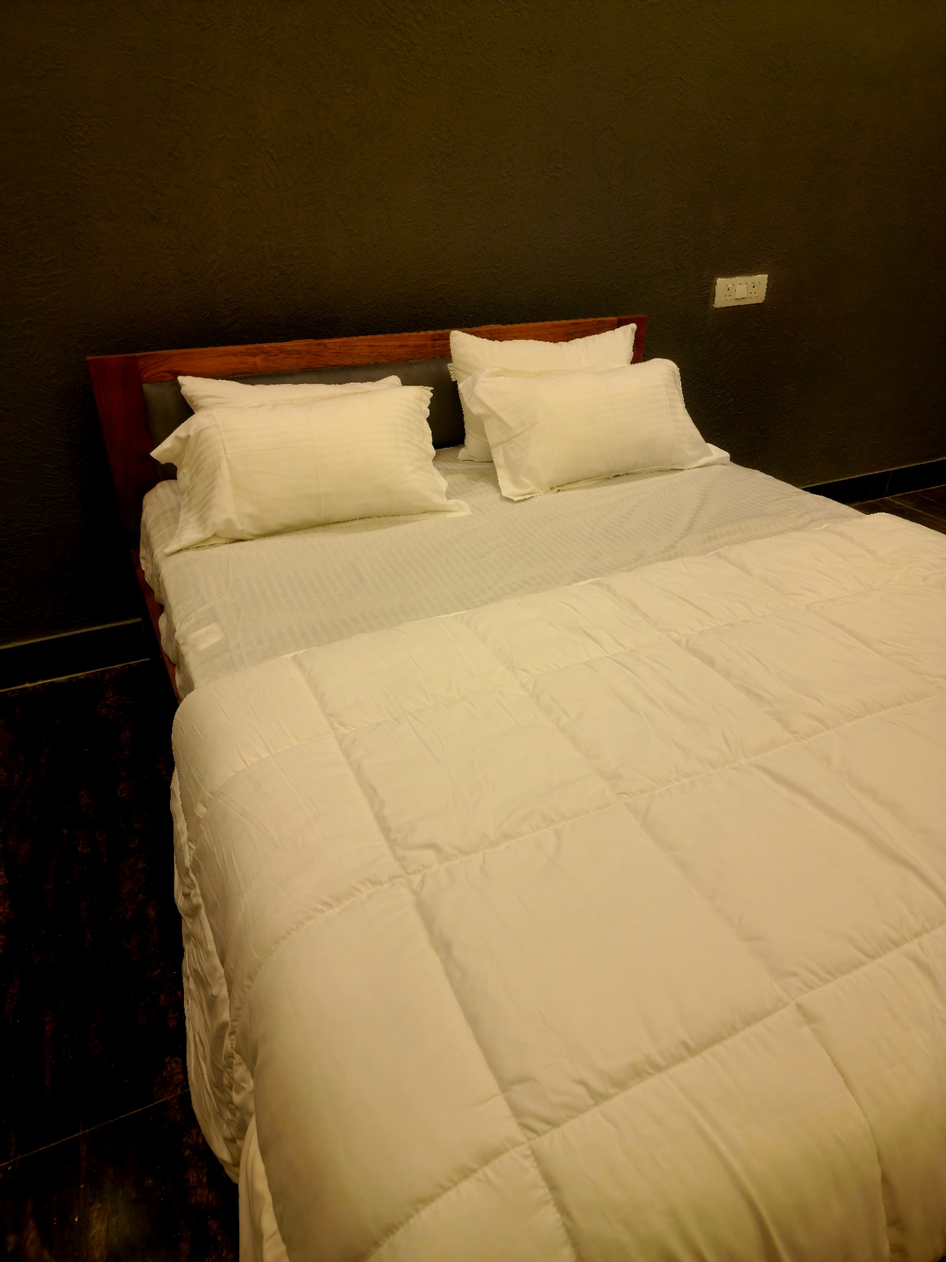 Queen bed with crisp white linen and wooden headboard