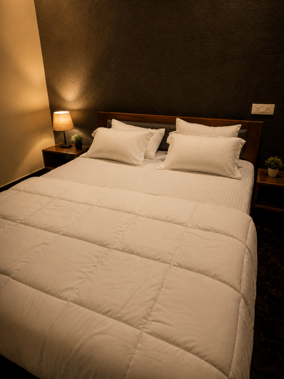 Boutique bedroom with textured accent wall and crisp linen — ARMS Suites
