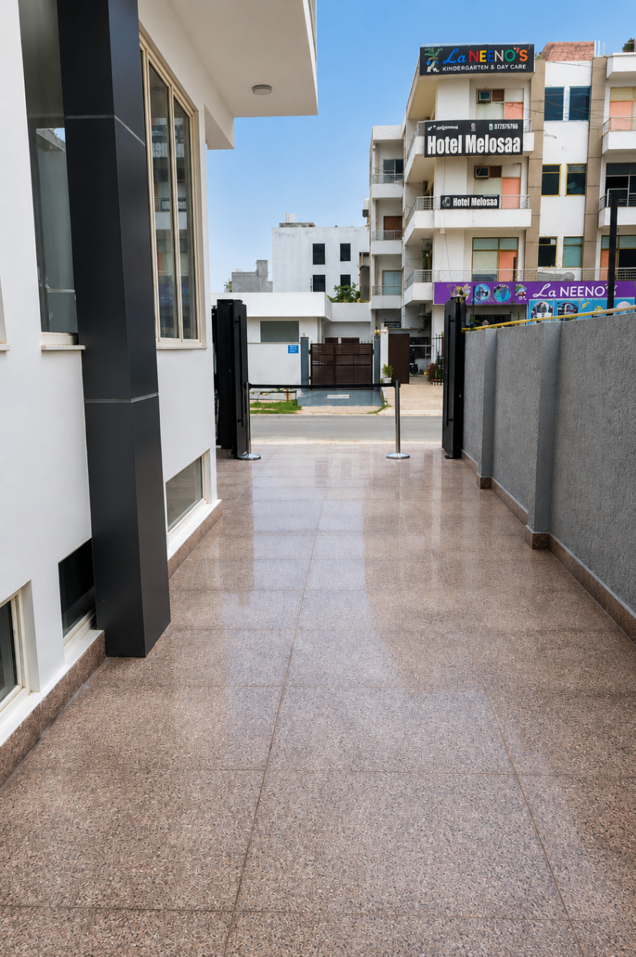 Entrance walkway and secure gated entry — ARMS Suites Noida