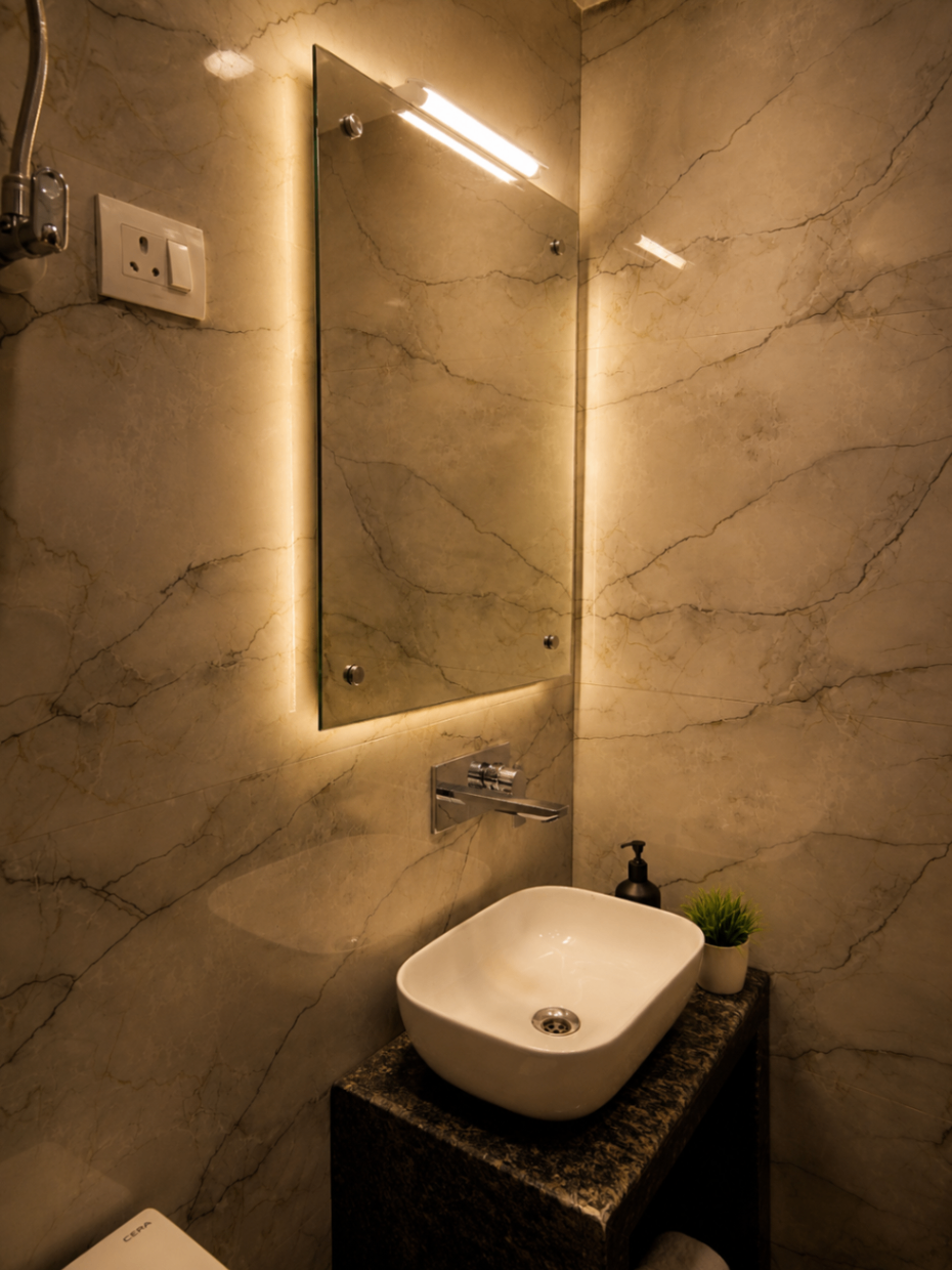 Backlit mirror and vessel basin in marble bathroom